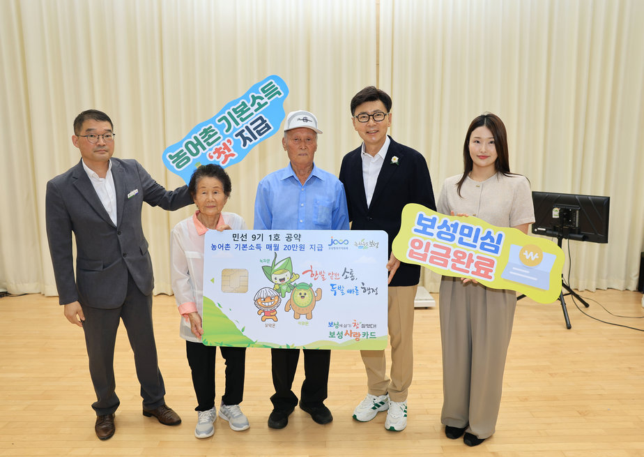 1-2. 보성군이 28일 농어촌 기본소득을 처음 지급했다_겸백면민의 날 행사장에서 첫 지급을 기념해 장수 노인 부부에게 주민 대표로 보성사랑상품권 카드 모형을 전달했다.jpg